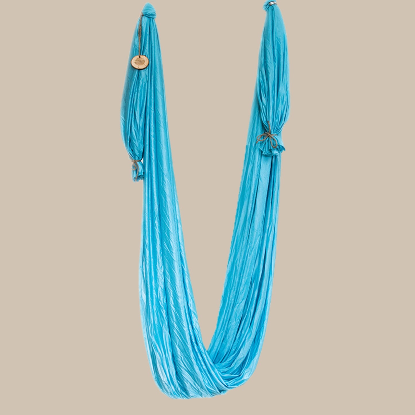 Aerial Yogatuch in sanftem Türkisblau mit Affirmation auf gravierter Baumscheibe